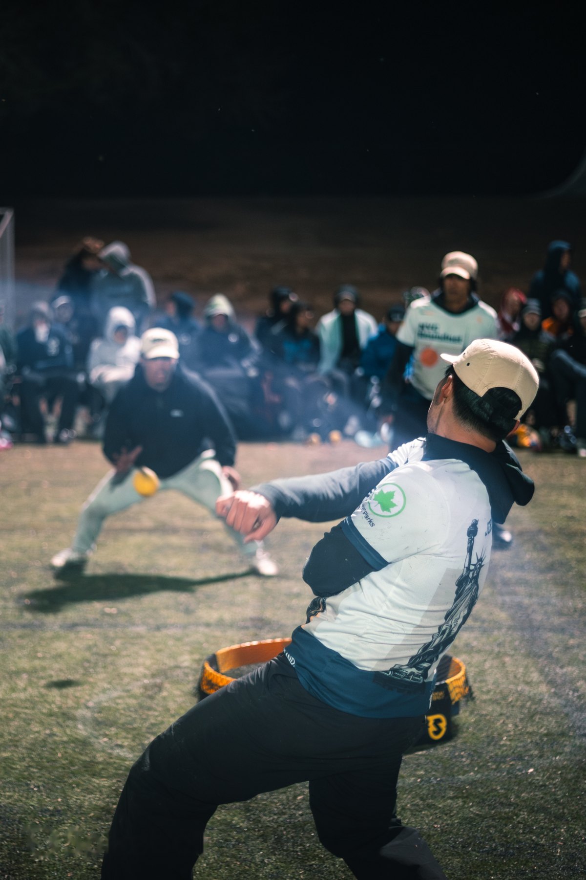 A player down on one knee after a rally under the lights